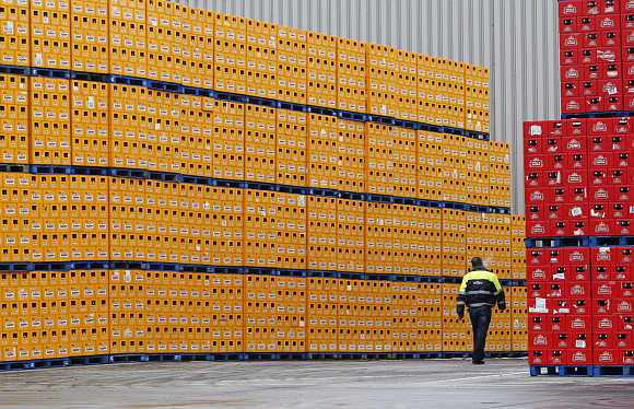 A worker inspects racks of beer bottles at the Anheuser-Busch InBev's plant in Jupille near Liege, Belgium.