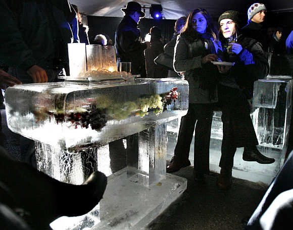 Wine enthusiasts sit on ice furniture in the tasting tent at the outdoor tasting session of the Niagara Grape and Wine Festival in Niagara-on-the-Lake, Canada.