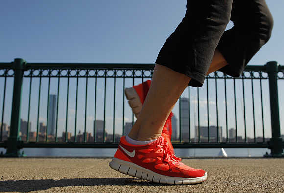A jogger wearing Nike shoes runs along the Charles River in Cambridge, Massachusetts.