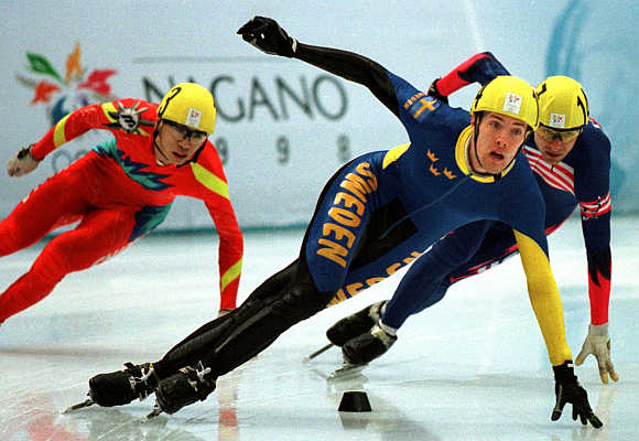 Sweden's Martin Johansson, centre, leads Andrew Gabel of the US, right, and Feng Kai of China, left. during the Olympic men's 1000 metre short track speed skating race in Nagano, China.