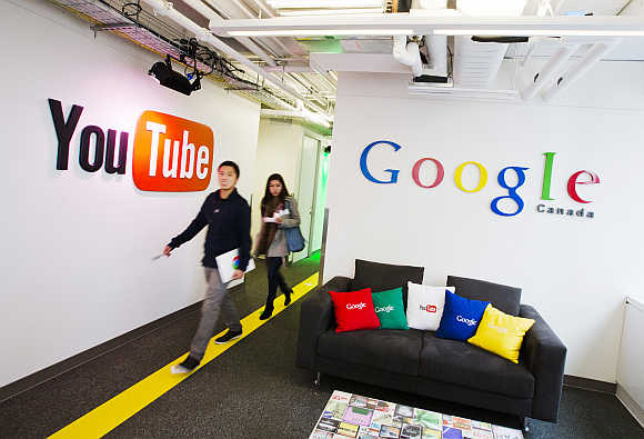 People walk by a YouTube sign at the Google office in Toronto, Canada.