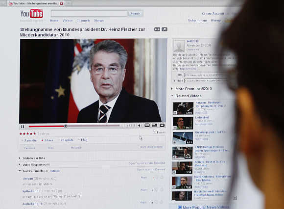 A journalist watches a video of Austrian President Fischer's announcement to run for President on YouTube in Vienna.