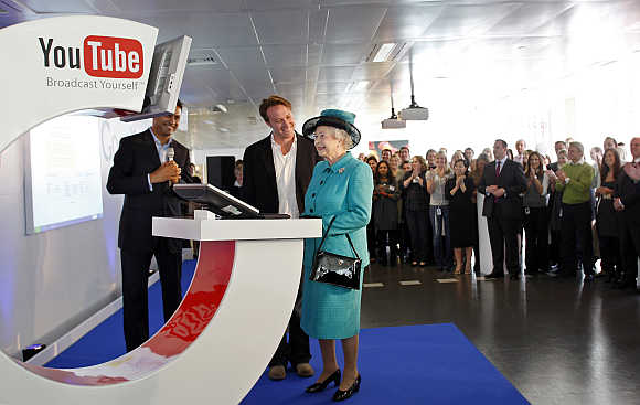 Britain's Queen Elizabeth uses a computer to upload a video to the Royal Channel on YouTube in London.