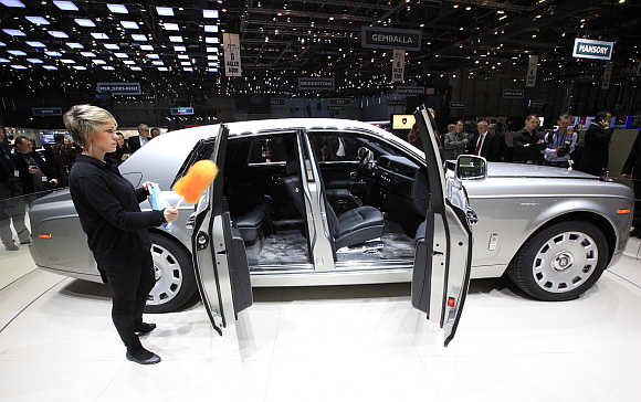 A worker cleans the Rolls Royce Phantom Series II in Geneva, Switzerland.