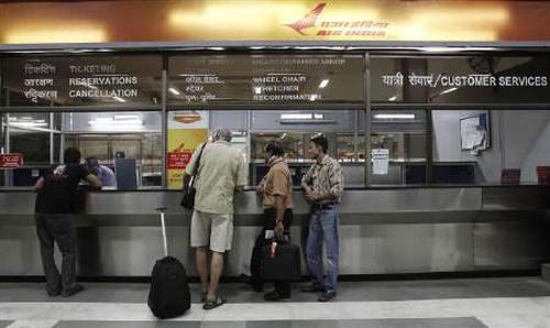 Passengers stand outside the Air India counter at the domestic airport in New Delhi.