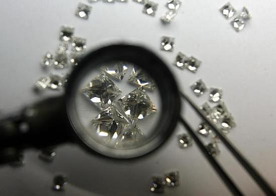 An employee at a diamond merchant's workshop inspects diamonds while grading them in Mumbai.
