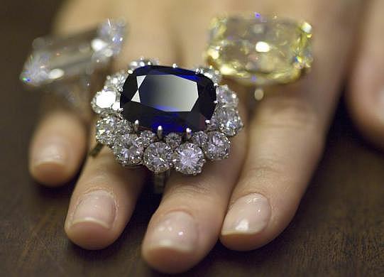 A Christie's employee wears a sapphire (33.23 carats) and diamond ring by Repossi (centre).