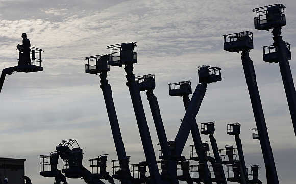 A worker stands on a crane at a construction site at Keihin industrial zone in Kawasaki, south of Tokyo.