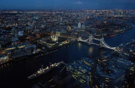 Tower Bridge and the Canary Wharf financial district are seen at dusk in an aerial photograph.