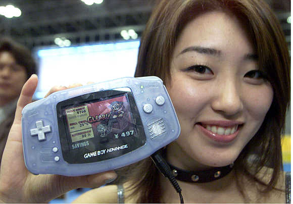 A Nintendo promotion woman shows off the next-generation hand-held console Game Boy Advance in Tokyo, Japan.