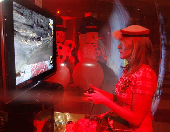 A woman in a costume plays a game on the Sony Playstation 3 in Beverly Hills.