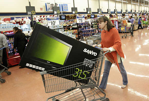 A shopper pushes a cart with a television screen at a Walmart store in Mexico City, Mexico.