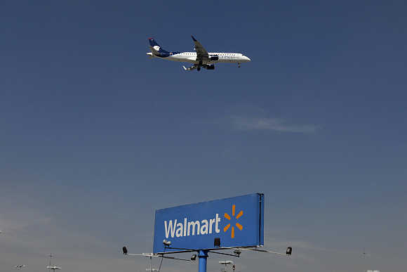 An aeroplane flies over a Walmart billboard in Mexico City, Mexico.