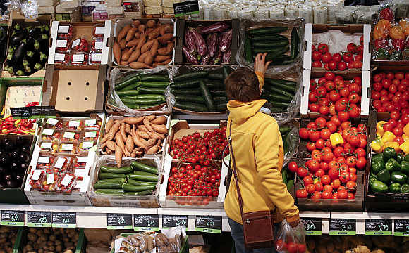 A woman checks vegetables at an organic supermarket in Berlin, Germany.