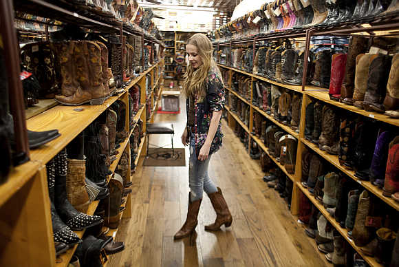 Cristina Grace arranges merchandise in Allen's Boots on South Congress in Austin, Texas.