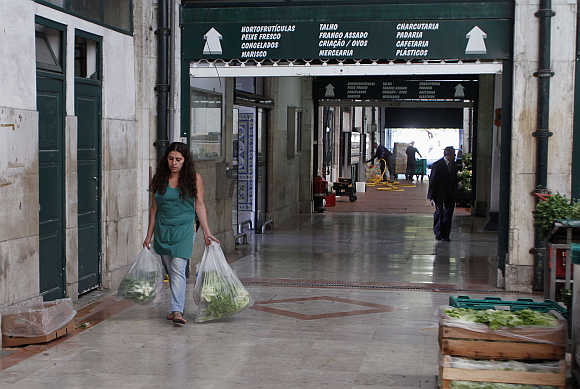 A woman carries shopping bags in Ribeira market in Lisbon, Portugal.