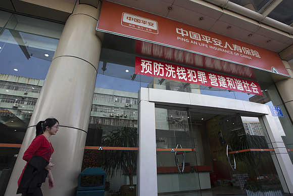 A woman walks past a Ping An Insurance building in Shenzhen.