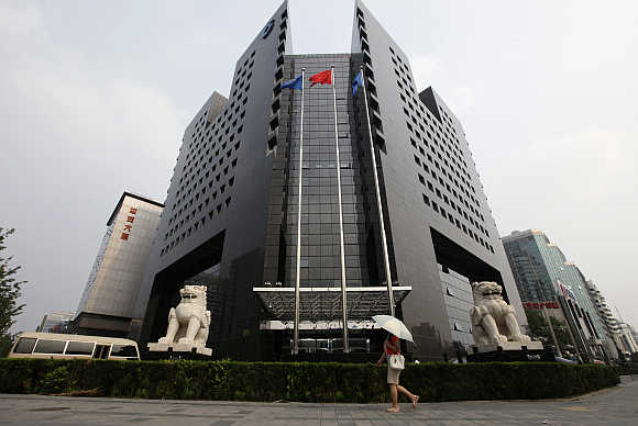 A woman walks in front of the China Construction Bank headquarters building in Beijing.