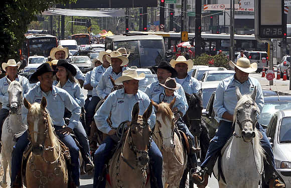 People ride horses along a main avenue in the financial centre of Sao Paulo.