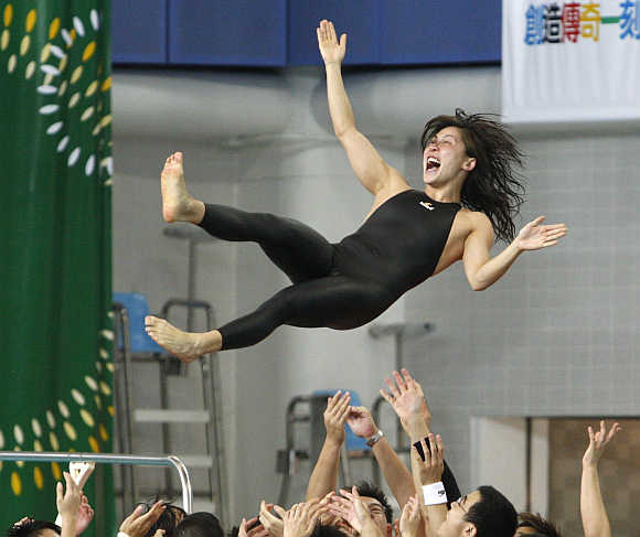 Tsai Hiu Wai is tossed into the air by teammates after competing in a competition in Hong Kong.