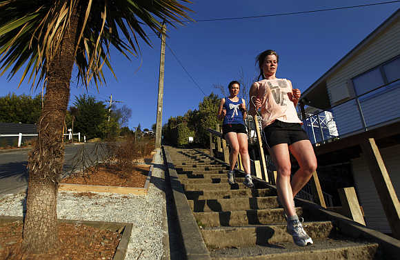 Women run down Baldwin street in Dunedin. Baldwin street is considered as one of the world's steepest streets.