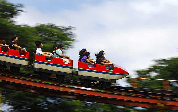 People ride on a roller coaster ride in Yangon Zoo playground in Burma.