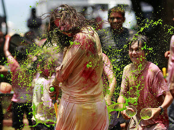 A boy splashes coloured water on a girl in Colombo.
