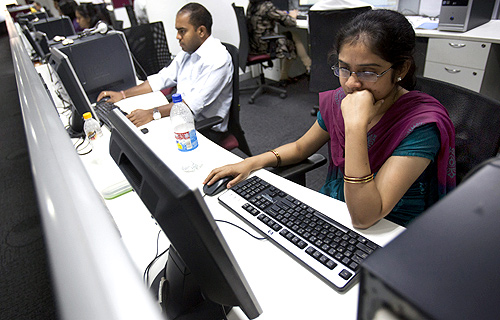 Employees work on their computer terminals on the floor of an outsourcing centre in Bengaluru.
