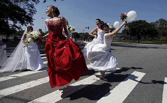 Women in wedding gowns jump on the street during a 'Parade of Brides' in Sao Paulo.