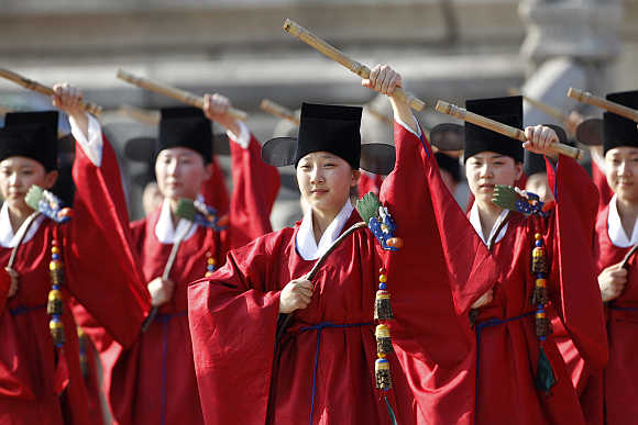 Performers in traditional Korean costumes dance during a welcoming ceremony for the Oegyujanggak books at Gyeongbok Palace in Seoul.