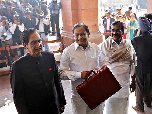 Finance Minister Palaniappan Chidambaram (C) arrives at the parliament to present the 2013/14 federal budget in New Delhi.