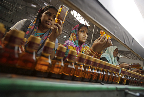 Bottling plant workers check bottles of Black Power whisky for impurities at a Tilaknagar Industries distillery and bottling unit in Srirampur.