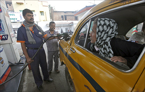A worker fills diesel in a taxi at a fuel station in Kolkata.