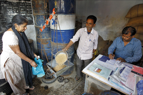 A woman buys wheat from a ration shop.