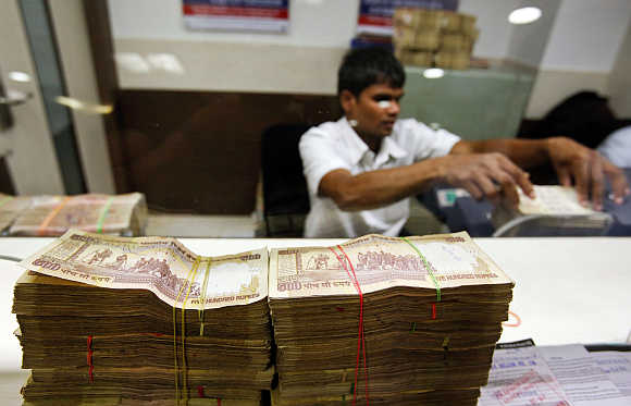 A teller counts currency notes at a bank in Mumbai.