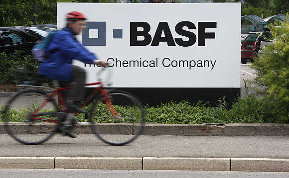 A cyclist rides his bike past the entrance of the BASF plant in Schweizerhalle near Basel, Switzerland.