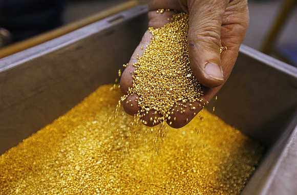 Worker checks gold granulate at refiner and bar manufacturer Valcambi in Swiss town of Balerna.