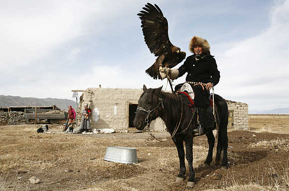 Elik Hamchvay poses with his hunting eagle Khana near Sagsay village in Altay montains in western Mongolia's Bayan Olgiy Province.