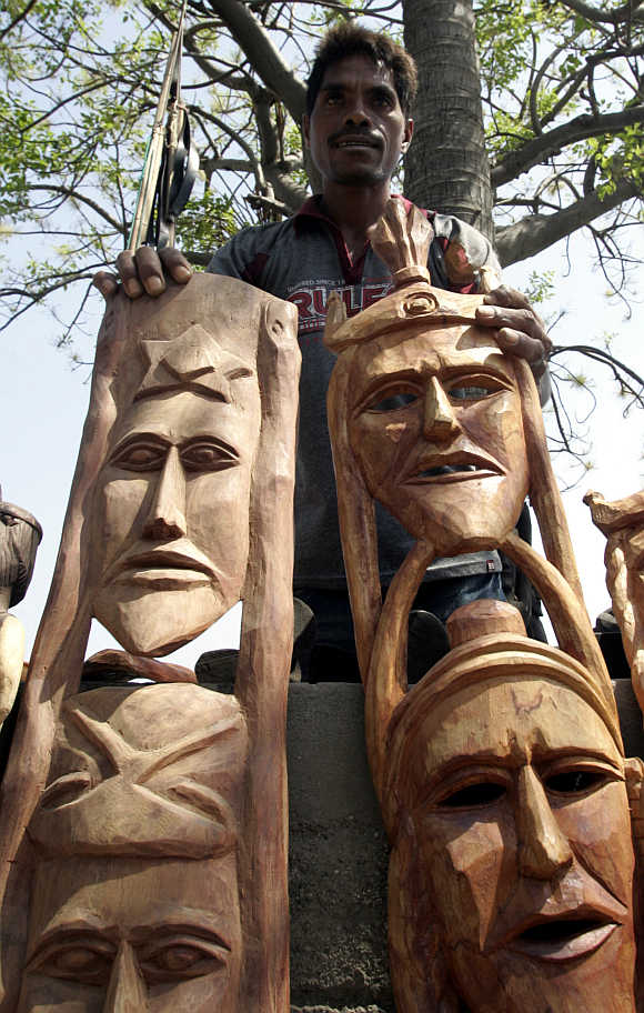 A man selling his carvings for $20 each waits for customers in Dili, East Timor.