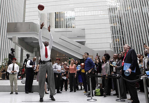 Former National Basketball Association All-Star and current NBA global ambassador Dikembe Mutombo shoots a basket in Washington.