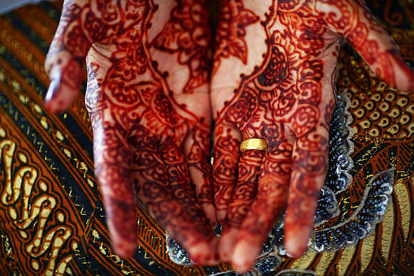 Winda Wahyuni shows her decorated hands and an engagement ring in Banda Aceh, Indonesia.