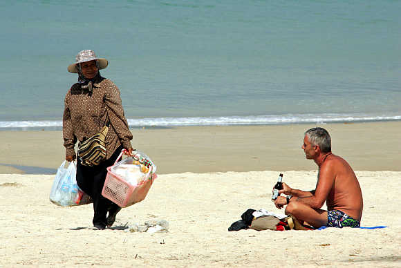 A tourist drinks beer at Patong Beach in Phuket.
