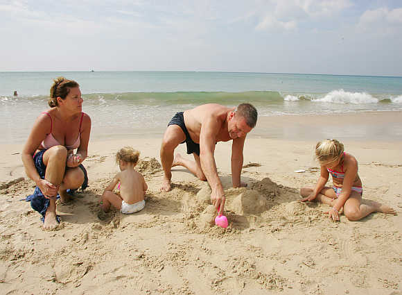 Peter Krantz from Sweden relaxes with his family on Kamala Beach in Phuket.
