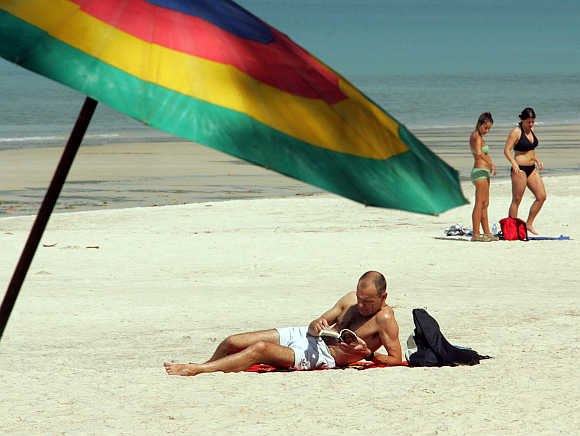 Beachgoers relax at Patong Beach in Phuket.