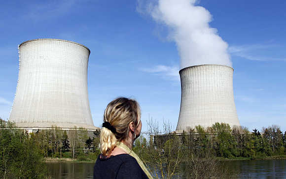 A woman looks at cooling towers of France's Electricite de France nuclear power station in Saint Laurent, Central France.