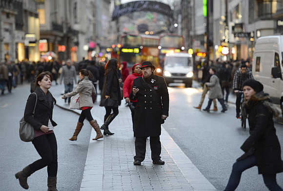 Pedestrians walk along Oxford Street in central London.