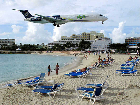 A small jet flies over Maho Beach in Sint Maarten.