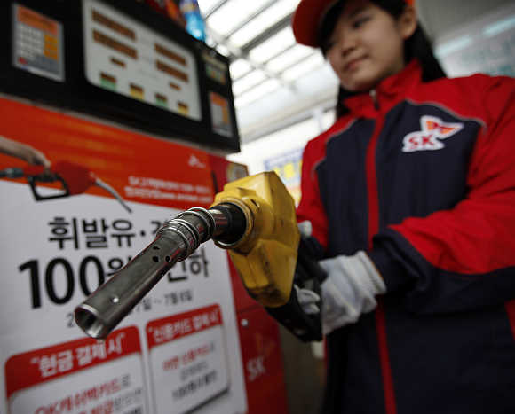 An employee holds a pump to refill a car in Seoul, South Korea.