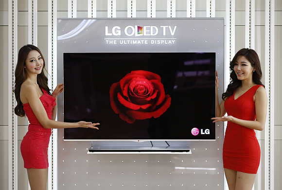 Models pose next to a LG Electronics' OLED television in Seoul.