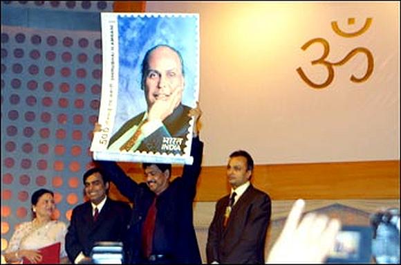 Late Pramod Mahajan holding a stamp commemorating Dhirubhai Ambani. He is flanked by Dhirubhai's sons Anil (right) and Mukesh, and wife Kokilaben (far left).
